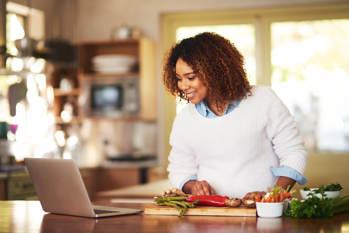 A woman looking at her computer and smiling.